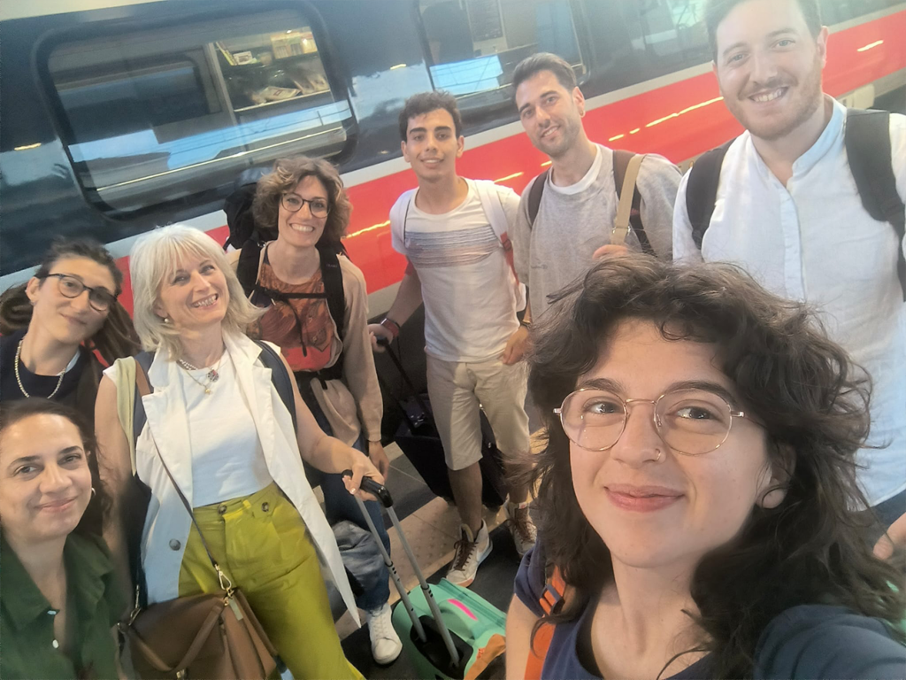 Gruppo di persone, team di Percorsi d'impresa, avanti al treno appena arrivato a Bologna