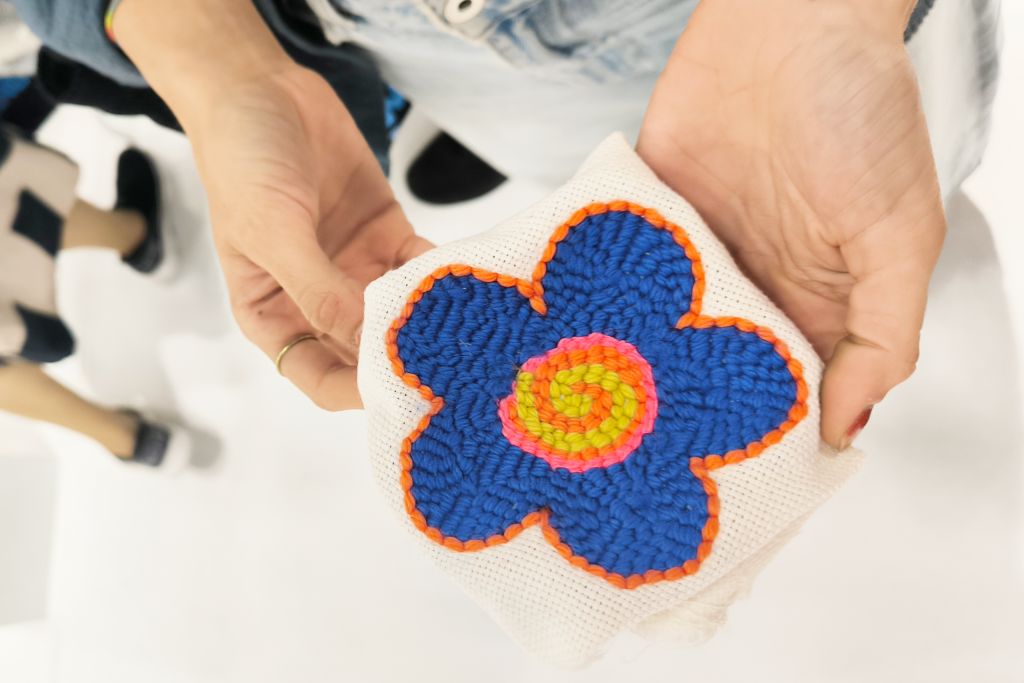 Un fiore ricamato durante un workshop, tra le mani di Paula