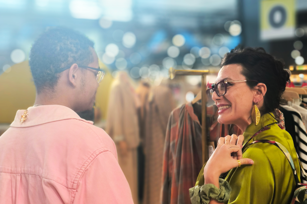 Roberta, beneficiaria della missione, sorride ad un possibile cliente all'interno di uno stand della fiera.