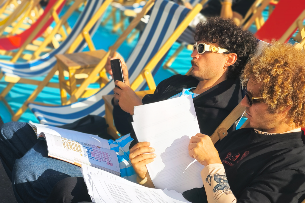 Sergio e Federico, due partecipanti alla missione, stesi su delle sdraio mentre fanno una ricognizione degli appuntamenti della giornata.